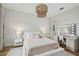 A charming bedroom features a queen bed, stylish chandelier, and a vanity with Hollywood-style mirror at 4109 W Inman Ave, Tampa, FL 33609