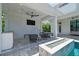 Covered patio with ceiling fan, outdoor TV, fire feature, and comfortable seating area by the pool at 4109 W Inman Ave, Tampa, FL 33609