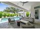 A covered patio offers stylish seating, a ceiling fan, and a view of the pool, spa, and outdoor kitchen at 4109 W Inman Ave, Tampa, FL 33609