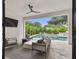 A luxurious outdoor patio with a ceiling fan, comfortable seating, and a view of the pool and landscaped backyard at 4109 W Inman Ave, Tampa, FL 33609