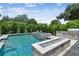 Outdoor living space featuring a pool, spa, fire feature, and kitchen for endless outdoor enjoyment at 4109 W Inman Ave, Tampa, FL 33609