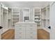 A large walk-in closet with custom shelving, storage island, and a view to the laundry room at 4109 W Inman Ave, Tampa, FL 33609