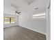 Bright bedroom with modern ceiling fan, light gray walls, and wood-look laminate flooring at 4652 Swallowtail Dr, New Port Richey, FL 34653