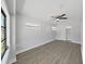 Comfortable bedroom featuring light gray walls, modern ceiling fan, and vinyl plank flooring at 4652 Swallowtail Dr, New Port Richey, FL 34653