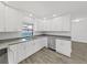 Updated kitchen boasts stainless steel dishwasher, granite countertops, and white cabinets at 4652 Swallowtail Dr, New Port Richey, FL 34653