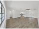 Bright, open-concept living area with hardwood floors, white walls, and access to the kitchen and pool area at 4652 Swallowtail Dr, New Port Richey, FL 34653