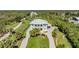 Aerial view of a stunning white home with beautiful landscaping, circular driveway, and private setting at 4710 Troydale Rd, Tampa, FL 33615