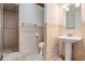 Tiled bathroom with glass enclosed shower, pedestal sink, and modern fixtures at 4710 Troydale Rd, Tampa, FL 33615