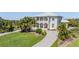 Stunning two-story home with a well-manicured lawn, a long driveway, and lush tropical landscaping at 4710 Troydale Rd, Tampa, FL 33615