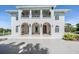 Elegant two-story home featuring a grand facade with arched entryways, a balcony, and a lush landscaped yard at 4710 Troydale Rd, Tampa, FL 33615