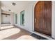 Elegant entryway with a large wooden front door, tile flooring, and decorative lighting fixtures at 4710 Troydale Rd, Tampa, FL 33615
