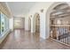 Hallway with tiled floors, decorative arches and railings, leading to other areas of the house at 4710 Troydale Rd, Tampa, FL 33615