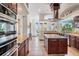 Gourmet kitchen featuring stainless steel appliances, rich wood cabinetry, granite countertops, and a center island at 4710 Troydale Rd, Tampa, FL 33615