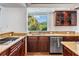Well-appointed kitchen features dark wood cabinetry, granite countertops, stainless steel appliances, and a bright window view at 4710 Troydale Rd, Tampa, FL 33615