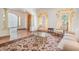 Bright living room featuring large windows, plush seating, elegant drapes, columns, and decorative rug at 4710 Troydale Rd, Tampa, FL 33615