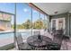 Covered patio with outdoor seating overlooking the sparkling pool and lush landscaping at 4710 Troydale Rd, Tampa, FL 33615