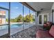 Relaxing screened-in patio area overlooking a sparkling swimming pool and tropical landscaping at 4710 Troydale Rd, Tampa, FL 33615