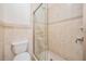 Shower featuring neutral tile, glass door, and a shower head at 4710 Troydale Rd, Tampa, FL 33615