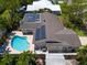 Aerial view of a backyard featuring a pool, solar panels and a beautiful patio perfect for entertaining at 4739 114Th N St, St Petersburg, FL 33708