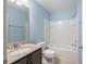 Bathroom featuring a vanity with granite countertop, a shower-tub combo, and blue walls at 4743 Somerset Hill Ln, Riverview, FL 33578