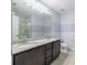 Bathroom with a dual sink vanity, granite countertop, large mirror, and tiled shower at 4743 Somerset Hill Ln, Riverview, FL 33578