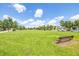 Expansive grassy field with a bench, trees, and cars, offering a serene and open space for recreation at 4743 Somerset Hill Ln, Riverview, FL 33578