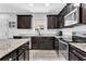 Modern kitchen featuring dark cabinets, granite countertops, and stainless steel appliances at 4743 Somerset Hill Ln, Riverview, FL 33578