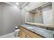 Bathroom with granite countertops and a tiled shower behind a large mirror at 4920 Anniston Cir, Tampa, FL 33647
