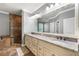 Bathroom featuring a large mirror, dual sinks, and a tiled shower at 4920 Anniston Cir, Tampa, FL 33647