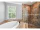 A luxurious tub and a glass-enclosed shower with decorative tilework are highlights at 4920 Anniston Cir, Tampa, FL 33647