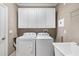 Functional laundry room with washer, dryer, storage cabinets, and utility sink at 4920 Anniston Cir, Tampa, FL 33647