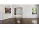 View of hardwood floors, arched doorways leading to dining and kitchen area, and natural lighting at 4920 Anniston Cir, Tampa, FL 33647