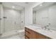 Modern bathroom featuring glass enclosed shower, wood cabinets, quartz countertop, large mirror, and neutral paint at 5120 Marina Way # 15005, Tampa, FL 33611
