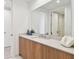 Modern bathroom featuring wood cabinets, quartz countertop, large mirror, and neutral paint at 5120 Marina Way # 15005, Tampa, FL 33611