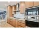 Gourmet kitchen featuring stainless steel appliances, custom cabinets, and a sleek cooktop with modern vent hood at 5120 Marina Way # 15005, Tampa, FL 33611