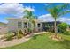 Charming backyard with lush lawn, a brick paver walkway, well-manicured landscaping, and screened-in patio at 537 Ocean Spray Dr, Ruskin, FL 33570