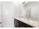Well lit bathroom featuring double sinks, dark cabinets, and a large mirror with a view into the toilet and shower space at 537 Ocean Spray Dr, Ruskin, FL 33570