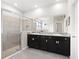 Modern bathroom featuring a double sink vanity, large mirror, and a glass-enclosed shower at 537 Ocean Spray Dr, Ruskin, FL 33570