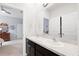 Bright bathroom featuring double sinks and a large mirror with a view into the bedroom and adjoining closet space at 537 Ocean Spray Dr, Ruskin, FL 33570