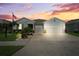 Charming single-story home featuring a well-manicured lawn, Florida landscaping, and a two-car garage at sunset at 537 Ocean Spray Dr, Ruskin, FL 33570