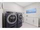 Functional laundry room with modern washer and dryer, storage cabinets, and tasteful decor at 537 Ocean Spray Dr, Ruskin, FL 33570