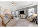 Spacious living room featuring a plush rug, comfortable seating, tray ceilings, and abundant natural light at 537 Ocean Spray Dr, Ruskin, FL 33570