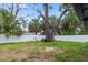 Lush backyard featuring a large tree and a white fence providing privacy at 5614 Bay Boulevard, Port Richey, FL 34668
