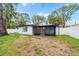 The backyard of the home has a screen porch and white fencing at 5614 Bay Boulevard, Port Richey, FL 34668