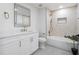 This bathroom features a tub-shower combo, white vanity with storage, and stylish brass fixtures at 5628 Terrain De Golf Dr, Lutz, FL 33558