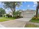 Attractive single-Gathering home with mature trees, lush landscaping, and a spacious driveway with two-car garage at 5628 Terrain De Golf Dr, Lutz, FL 33558