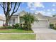 Inviting single-Gathering home with a well-maintained lawn, beautiful landscaping, and a two-car garage at 5628 Terrain De Golf Dr, Lutz, FL 33558