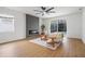 Open living room with fireplace, sliding doors to pool, modern ceiling fan and wood floors at 5628 Terrain De Golf Dr, Lutz, FL 33558