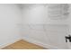Walk-in closet with wood floors and wire shelving at 5628 Terrain De Golf Dr, Lutz, FL 33558