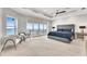 Modern bedroom with water view, tray ceiling, ceiling fan and sitting area at 6418 Bright Bay Ct, Apollo Beach, FL 33572
